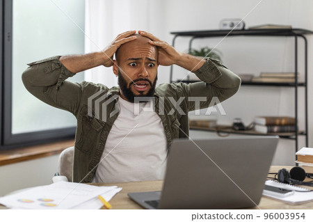 Oh no, error concept. Shocked mature latin man using pc, gasping with open mouth and grabbing his head, sitting at desk Oh no, error concept. Shocked mature latin man using pc, gasping with open mouth and grabbing his head, sitting at desk 96003954