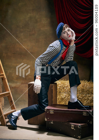 Vintage portrait of male mime artist expressing sadness and loneliness over dark retro circus backstage background. Concept of emotions, art, fashion, style 96004189