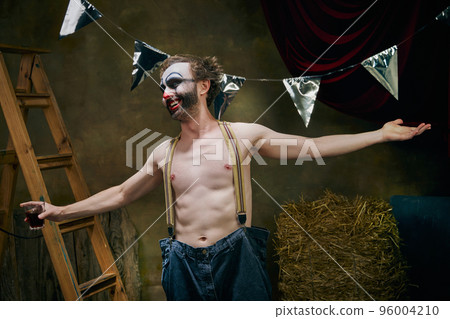 Sad male clown is sad, going through a personal tragedy, despair in the old retro circus backstage. Concept of fate, job, emotions, facial expression, mental health 96004210