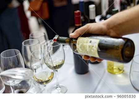 Wine. Glass of wine. Hands serving bottles of wine in transparent glasses for guests. Toast. Celebration day. Photography. 96005830