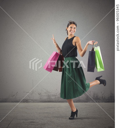 Shopaholic woman happy of her many purchases Shopaholic woman happy of her many purchases 96005845