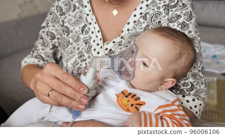Infant getting breathing treatment from mother while suffering from illness. Infant getting breathing treatment from mother while suffering from illness. 96006106