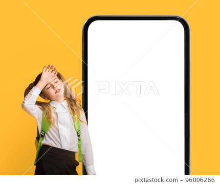 Tired Preteen Schoolgirl Standing Near Big Smartphone With Blank Screen 96006266