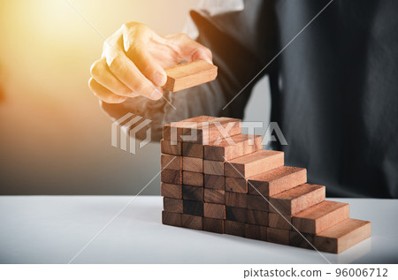 Business hand arranging put wooden block stacking step stair growth success process, financial risk management and strategic plan and business challenge planning concept, prevent collapse or crash 96006712