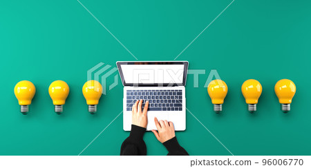 Person using a laptop computer with light bulbs Person using a laptop computer with light bulbs 96006770