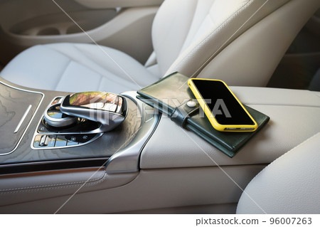 A telephone and purse lie on an elbow-rest in the salon of car 96007263