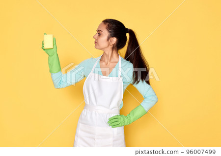 woman in gloves and cleaner apron cleaning with yellow sponge woman in gloves and cleaner apron cleaning with yellow sponge 96007499