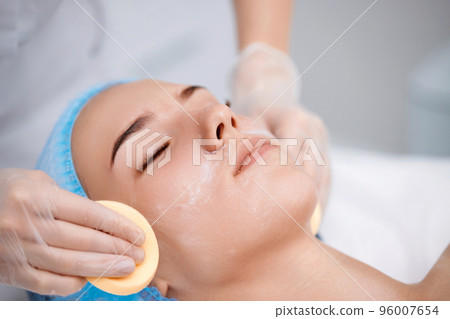 beautician cleanses skin of beautiful woman with a sponge. beautician cleanses skin of beautiful woman with a sponge. 96007654