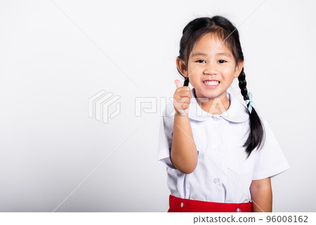 Asian adorable toddler smiling happy wear student thai uniform red skirt show thumb up finger in studio shot isolated on white background, Portrait little children girl preschool, Kid Back to school 96008162