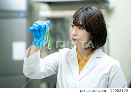 A woman in a white coat doing research A woman in a white coat doing research 96008169