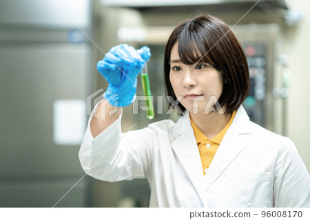 A woman in a white coat doing research 96008170