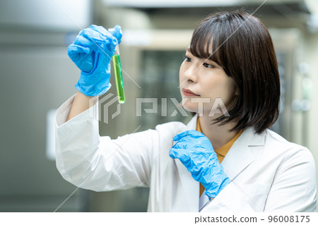 A woman in a white coat doing research 96008175