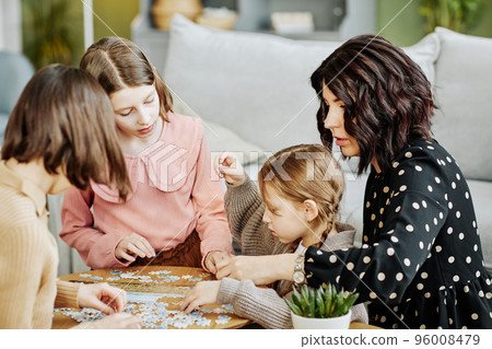 Mother with Three Kids Doing Puzzles Mother with Three Kids Doing Puzzles 96008479