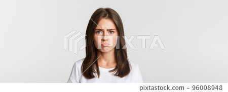 Close-up of sad brunette girl sulking and looking upset Close-up of sad brunette girl sulking and looking upset 96008948