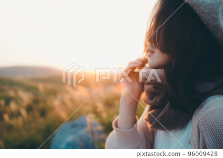 日落時站在大自然中的女人的照片 96009428
