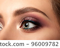 Closeup of green woman eye with smokey eyes makeup 96009782