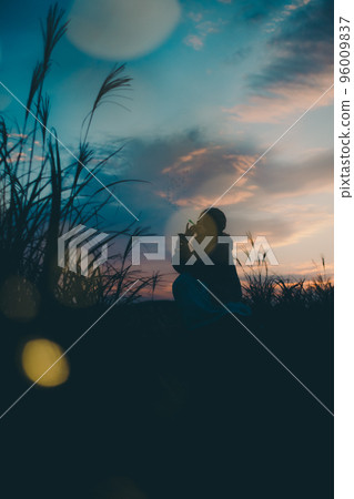 日落時站在大自然中的女人的剪影照片 96009837