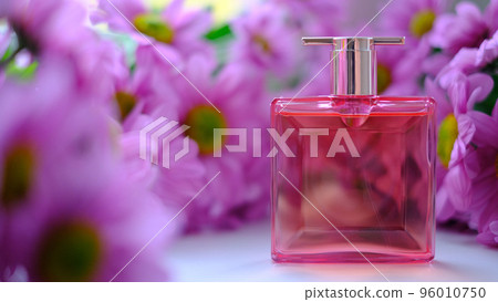 A perfume bottle surrounded by pink chrysanthemum flowers. Eau de toilette, eau de parfum, beauty concept 96010750