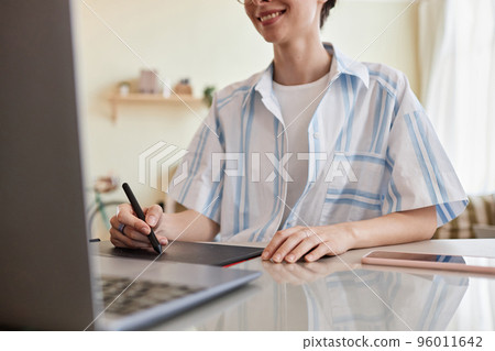 Young woman using pen tablet for digital design 96011642