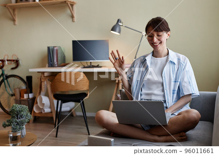 Young woman waving for video chat 96011661