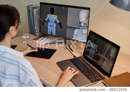 Female designer building digital 3D models for videogame 96011676
