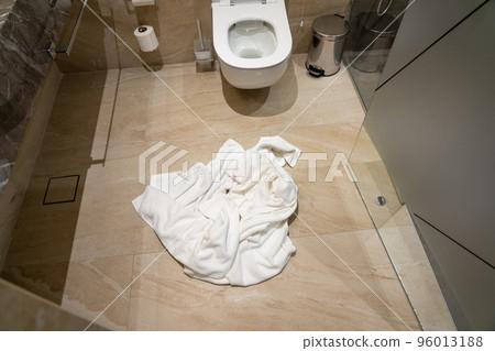 Crumpled used towel on the bathroom floor Crumpled used towel on the bathroom floor 96013188