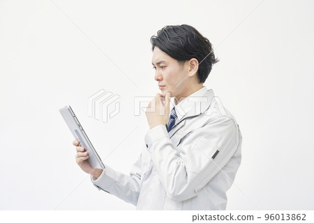 看著平板電腦和思考白色背景的工人 96013862