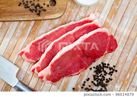 close up of pieces of marbled beef on wooden table close up of pieces of marbled beef on wooden table 96014879