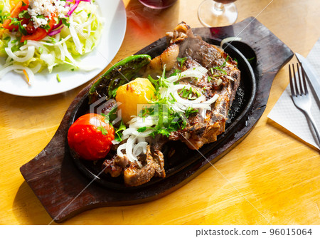 Grilled beef chop dinner served with vegetable garnish 96015064