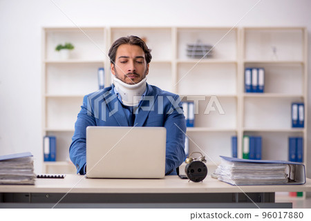 Young male employee after accident sitting at workplace 96017880