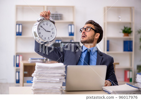 Young male employee in time management concept Young male employee in time management concept 96017976