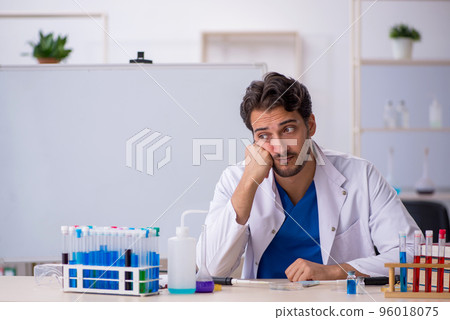 Young male chemist working at the lab 96018075