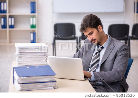 Young businessman employee and too much work in the office Young businessman employee and too much work in the office 96018520