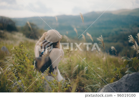 Photo of a woman holding a camera in nature Photo of a woman holding a camera in nature 96019100