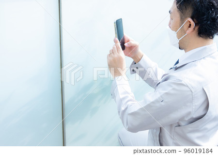 A worker taking a picture of the outer wall 96019184