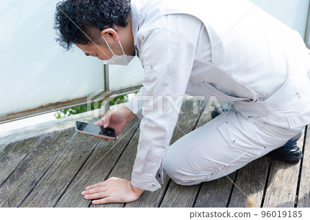 A worker inspecting the wood deck 96019185