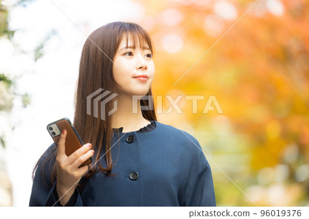 A woman in a coat walking outdoors 96019376