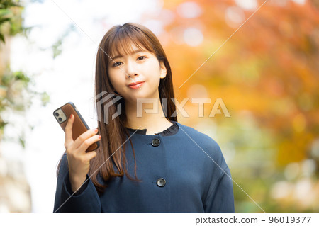 A woman in a coat walking outdoors 96019377