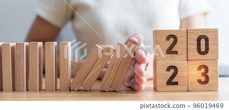 Hand stop falling blocks with 2023 year. Risk Management, recession, business financial, Resolution, strategy, goal, New Year planning and inflation economy concepts Hand stop falling blocks with 2023 year. Risk Management, recession, business financial, Resolution, strategy, goal, New Year planning and inflation economy concepts 96019469