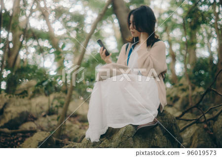 Photo of a woman listening to music in nature Photo of a woman listening to music in nature 96019573