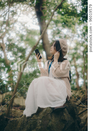 Photo of a woman listening to music in nature 96019579