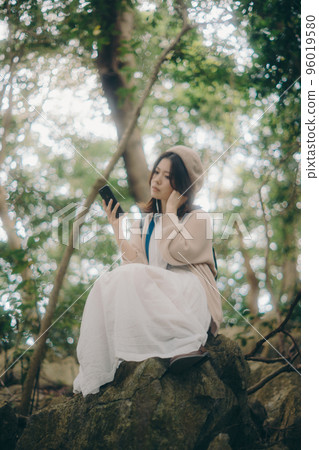 Photo of a woman listening to music in nature 96019580