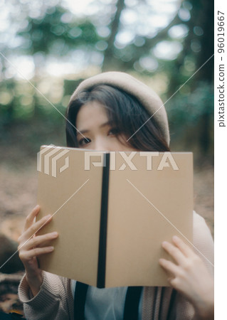 Photo of a woman doing creative activities while listening to music in nature 96019667