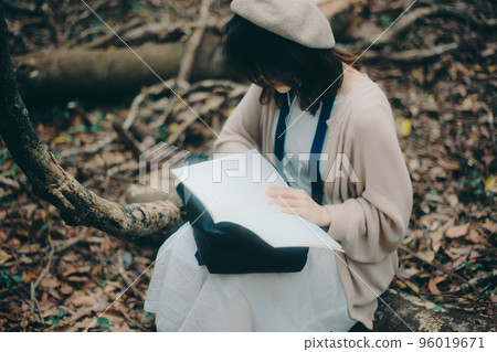 Photo of a woman doing creative activities while listening to music in nature Photo of a woman doing creative activities while listening to music in nature 96019671