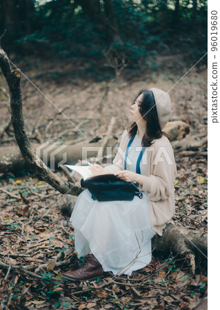 Photo of a woman doing creative activities while listening to music in nature Photo of a woman doing creative activities while listening to music in nature 96019680