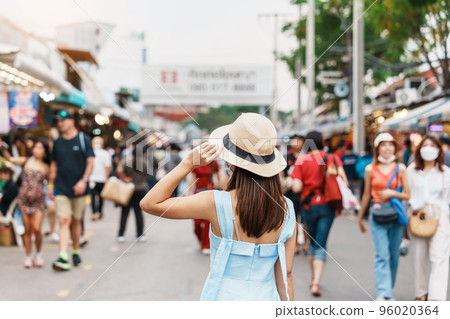 woman traveling with hat, Asian traveler standing at Chatuchak Weekend Market, landmark and popular for tourist attractions in Bangkok, Thailand. Travel in Southeast Asia concept 96020364