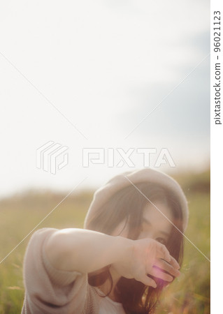 日落時站在大自然中的女人的照片 96021123
