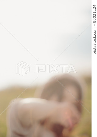 Photo of a woman standing in nature at sunset 96021124