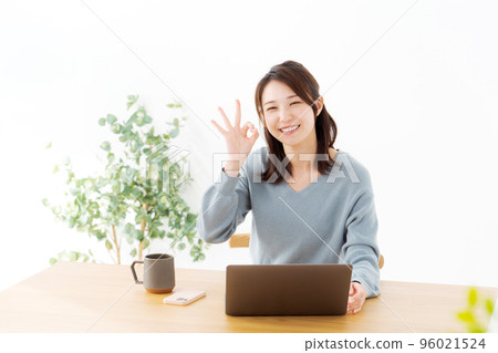 Woman operating a personal computer Woman operating a personal computer 96021524