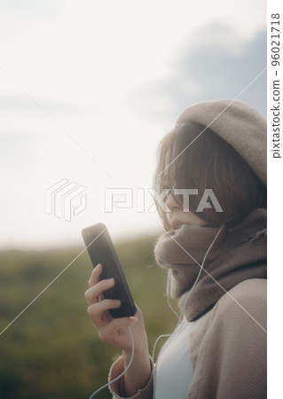 一個女人在大自然中聽音樂的照片 96021718